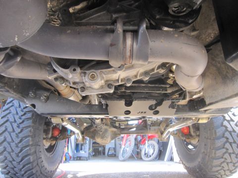 2008 Jeep Wrangler - The underside of a vehicle is shown, with a JSS skid plate and large tires, while two motorcycles are parked in the background.