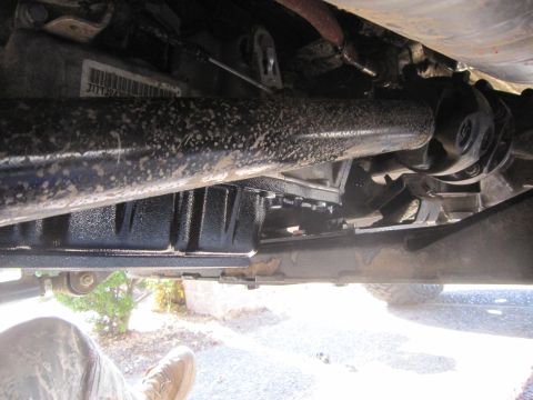 2008 Jeep Wrangler - Underside view shows the vehicle's drivetrain components, including the driveshaft and transmission pan.