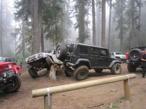 2008 Jeep Wrangler - Multiple off-road vehicles are gathered in a foggy forest setting.