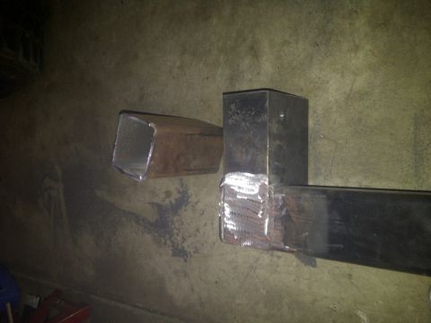 1995 Ford Bronco - This photo shows two metal tubes, one with a bracket, likely a part for fabrication or repair.
