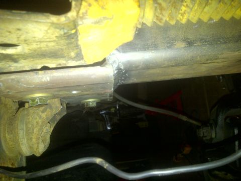 1995 Ford Bronco - Close-up view of the underside of a vehicle, showing mechanical parts and wiring.