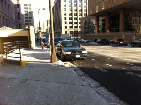 2003 Ford Crown Victoria - A black Ford Crown Victoria is parked on a city street with snow on the ground.