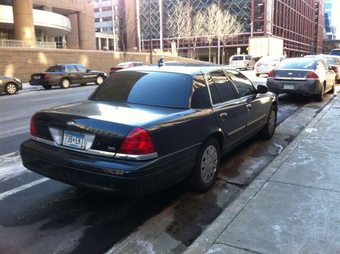 2003 Ford Crown Victoria - Rear view of a black 2003 Ford Crown Victoria parked curbside on a city street.