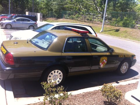 2003 Ford Crown Victoria - A Maryland State Trooper car, a 2003 Ford Crown Victoria, is parked in a lot.