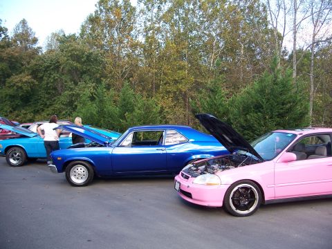 1971 Ford Ranchero - Cars parked in a lot with their hoods open, showing engines and interiors.