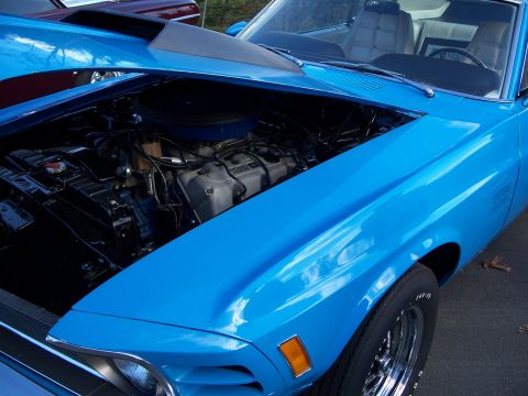 1971 Ford Ranchero - The engine bay of a bright blue muscle car is visible with the hood raised.