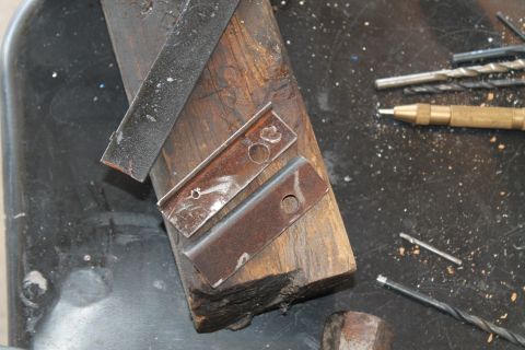 1990 Ford Bronco - Metal brackets and tools are laid out on a workbench, suggesting a repair or fabrication project.
