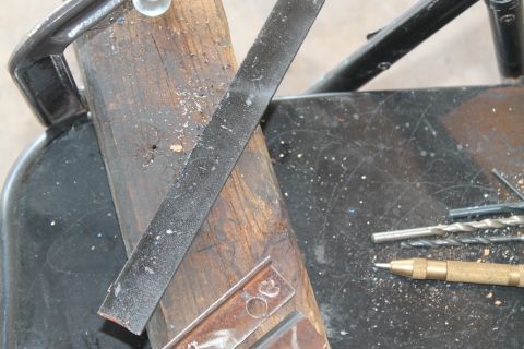 1990 Ford Bronco - Workbench setup with various tools including drill bits and a file, Supermotors.net logo present.