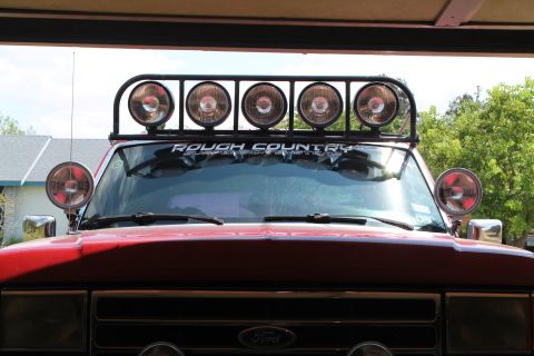 1990 Ford Bronco - Front view of a red 1990 Ford Bronco equipped with a "Rough Country" light bar and auxiliary lights.