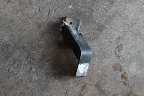 1990 Ford Bronco - A metal bracket, possibly a mounting bracket, is shown on a concrete surface.