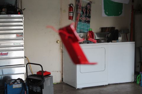 1990 Ford Bronco - A red plastic part is blurred in the foreground of a garage scene with laundry appliances.