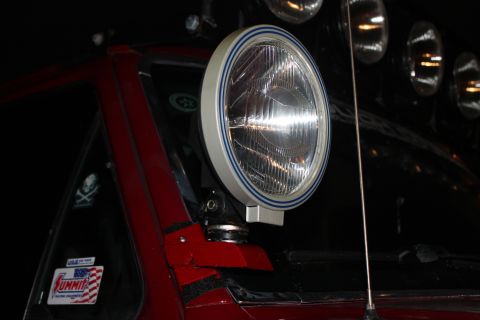 1990 Ford Bronco - Auxiliary light with blue bezel stripe mounted on a vehicle, with a Summit sticker on the window.