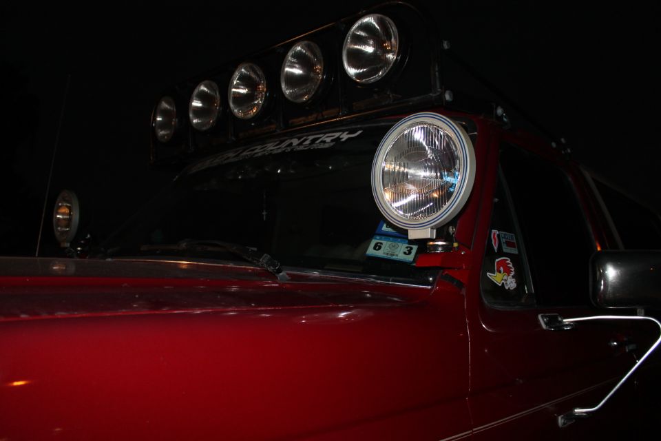 1990 Ford Bronco with roof-mounted light bar and a large auxiliary light on the A-pillar