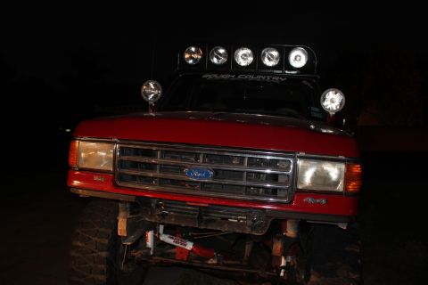 1990 Ford Bronco - This Ford truck features a prominent grille and a light bar mounted on the roof.