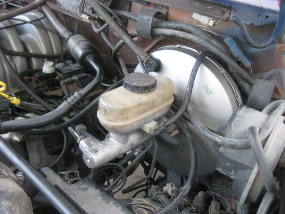 Brake master cylinder and booster assembly in engine bay