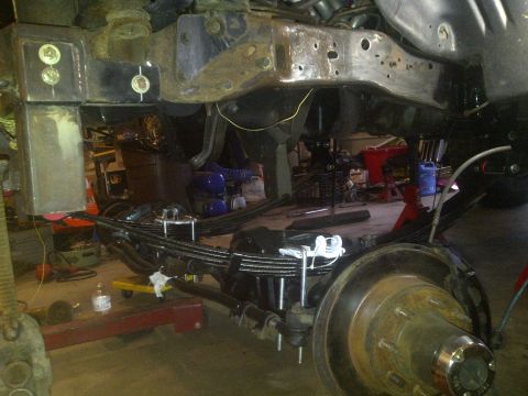 1995 Ford Bronco - Close-up view of the suspension and brake components of a vehicle, likely undergoing maintenance or modification.