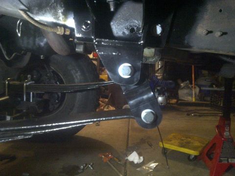 1995 Ford Bronco - Underneath view of a vehicle's suspension system, showing a newly installed bracket.