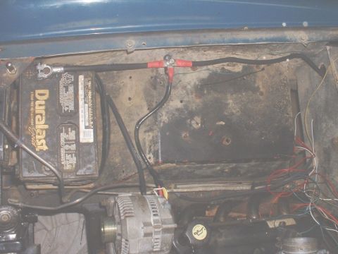 1986 Ford Bronco - Engine bay components including battery and alternator are visible, with wiring and cables connected.