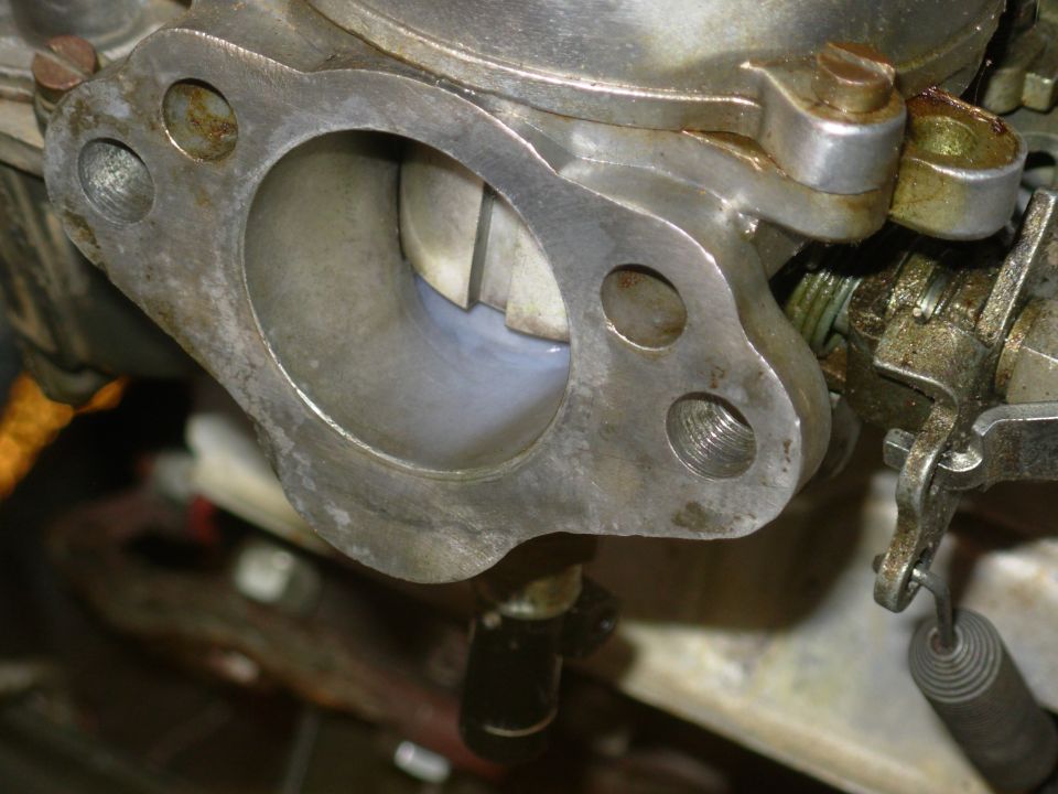 As the rear carb's throat drains, the front emanates fuel fog.