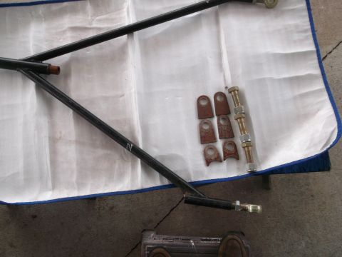 1971 Ford Ranchero - Automotive suspension parts laid out on a white cloth, including metal arms and brackets with hardware.
