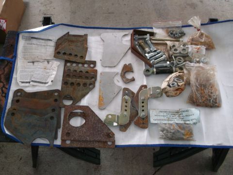 1971 Ford Ranchero - Various vehicle suspension components and hardware are spread out on a white surface, some in plastic bags.