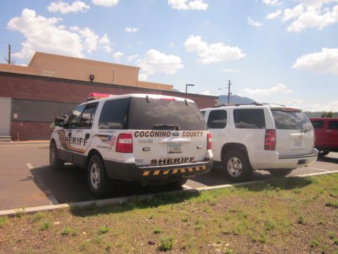 1991 Ford LTD Crown Victoria - Two sheriff SUVs are parked side-by-side in a lot. One is marked 'Coconino County Sheriff'.