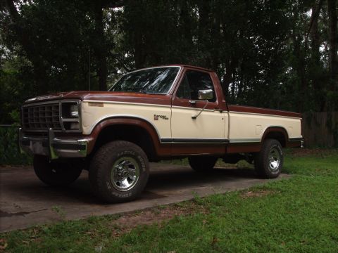 1980 Ford F-150 - A two-tone Ford F-150 pickup truck is shown from a three-quarter front angle, parked on a concrete driveway.