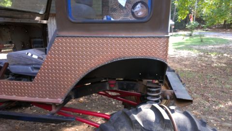 1978 Ford Bronco - This custom off-road vehicle features diamond plate fender flares and oversized tires, with visible suspension modifications.