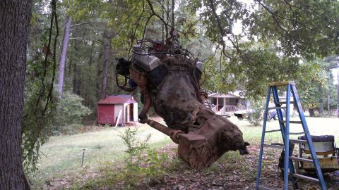 1978 Ford Bronco - An engine and transmission assembly is suspended from a tree, awaiting its next purpose.