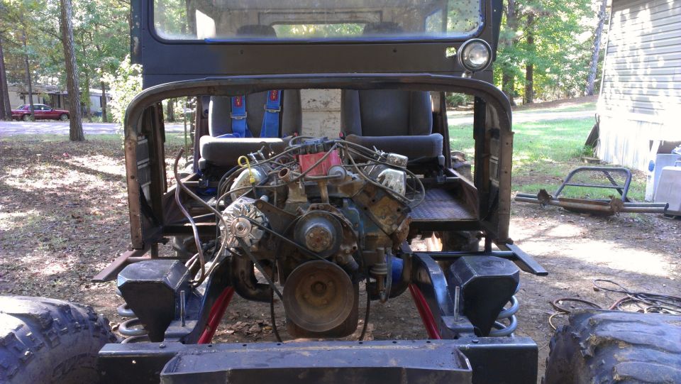 Vehicle interior with exposed engine, blue racing seats, and roll cage