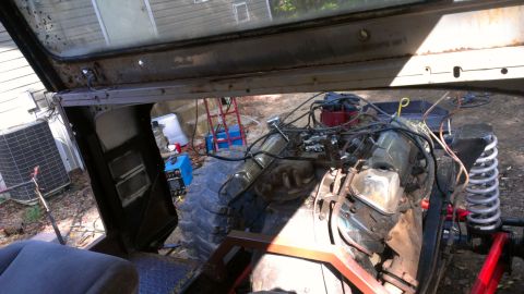 1978 Ford Bronco - Engine and chassis parts of a vehicle being worked on, viewed from the interior.