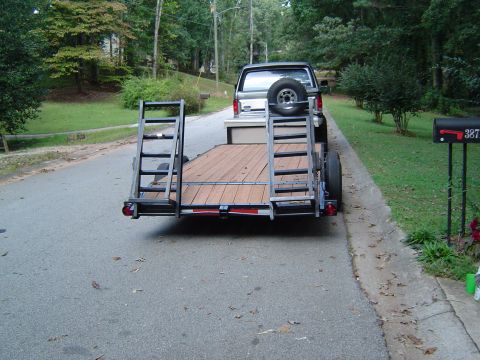1986 Ford Bronco - Trailer and pickup truck parked on a residential street.