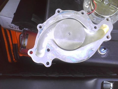 2003 Ford Crown Victoria - A close-up view of a water pump, showing its internal impeller and external mounting points.