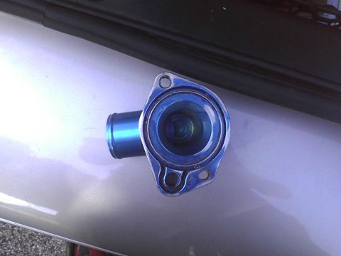 2003 Ford Crown Victoria - A blue thermostat housing is shown, likely a replacement part for a vehicle.