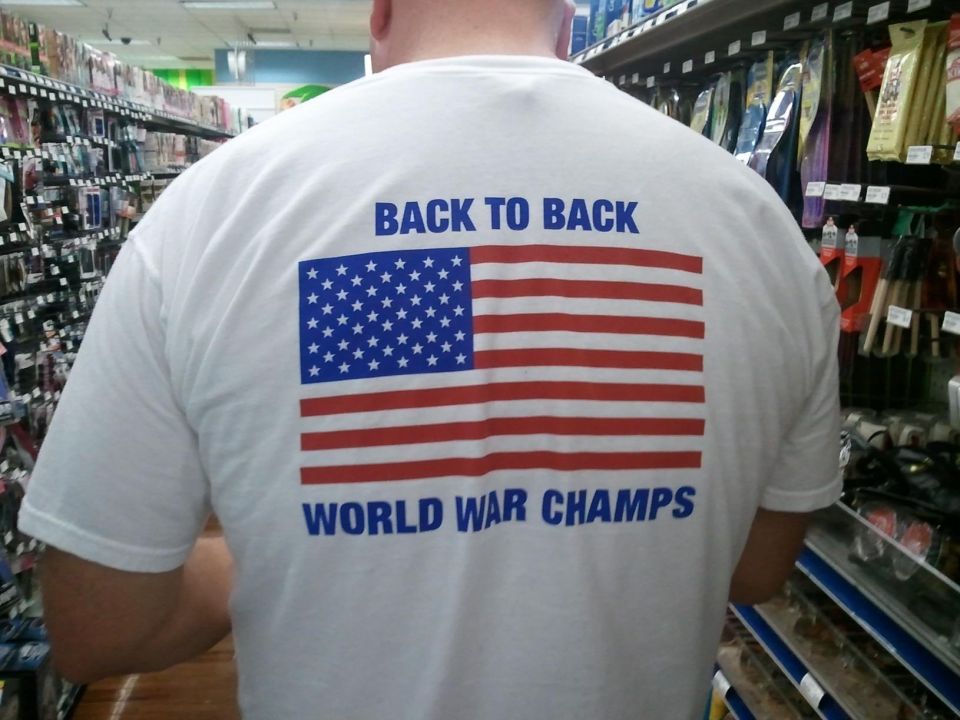 Guy in store wearing shirt that says 'BACK TO BACK WORLD WAR CHAMPS' with American flag