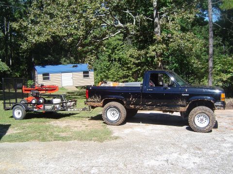 1989 Ford Ranger - Black 1989 Ford Ranger pickup truck towing a trailer with outdoor equipment.