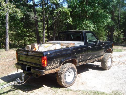 1989 Ford Ranger - This pickup truck, likely from the 1980s, is loaded with firewood and appears to be used for hauling.