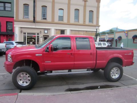 1991 Ford LTD Crown Victoria - A red crew cab pickup truck is parked on a street with buildings in the background.