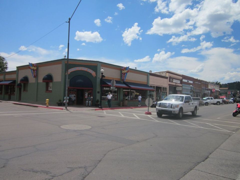 Street view of buildings on Route 66 with a white pickup truck driving