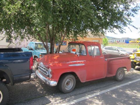 1991 Ford LTD Crown Victoria - A red 1955 pickup truck is parked next to other vehicles under a tree, with a 'For Sale' sign visible in the window.