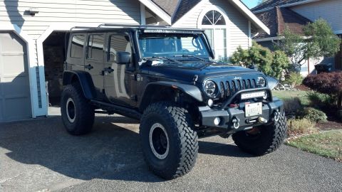 2008 Jeep Wrangler - This black Jeep Wrangler features a modified bumper and large tires, suggesting a model year later than 2008.