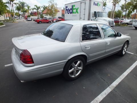 2003 Ford Crown Victoria - Silver four-door Marauder sedan parked near a FedEx truck, shown from the rear quarter angle
