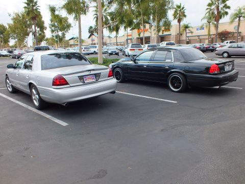 2003 Ford Crown Victoria - Silver Mercury Marauder and black Ford Crown Victoria parked tail to tail under palm trees
