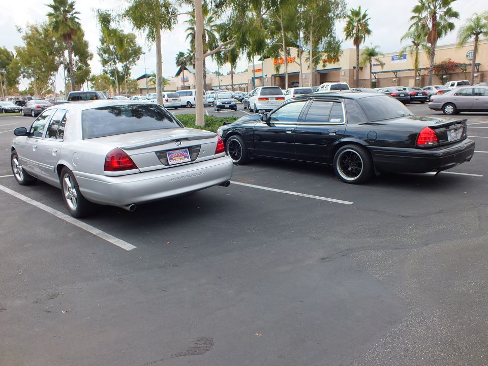 Silver Marauder and black Crown Victoria parked rear-to-rear in parking lot