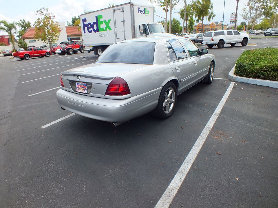 Silver Mercury Marauder rear three-quarter view parked near FedEx truck