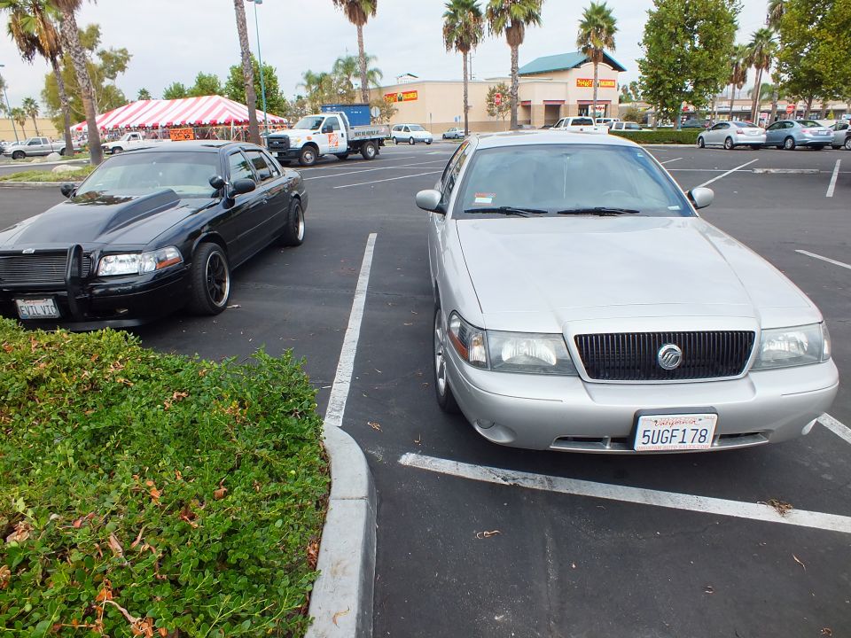Silver Mercury sedan front view with California plate 5UGF178 beside a black sedan