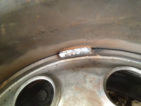 1989 Ford Bronco - Close-up of a damaged wheel rim that has been repaired with a weld.