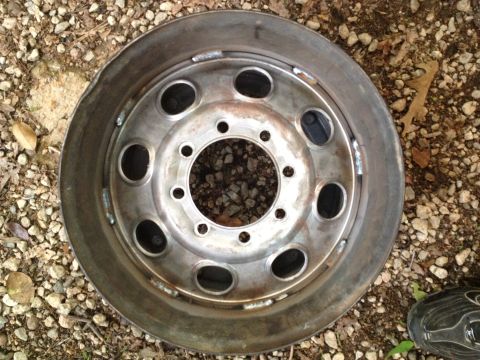 1989 Ford Bronco - A single wheel rim, possibly from a truck or heavy-duty vehicle, is shown with visible damage to its outer edge.