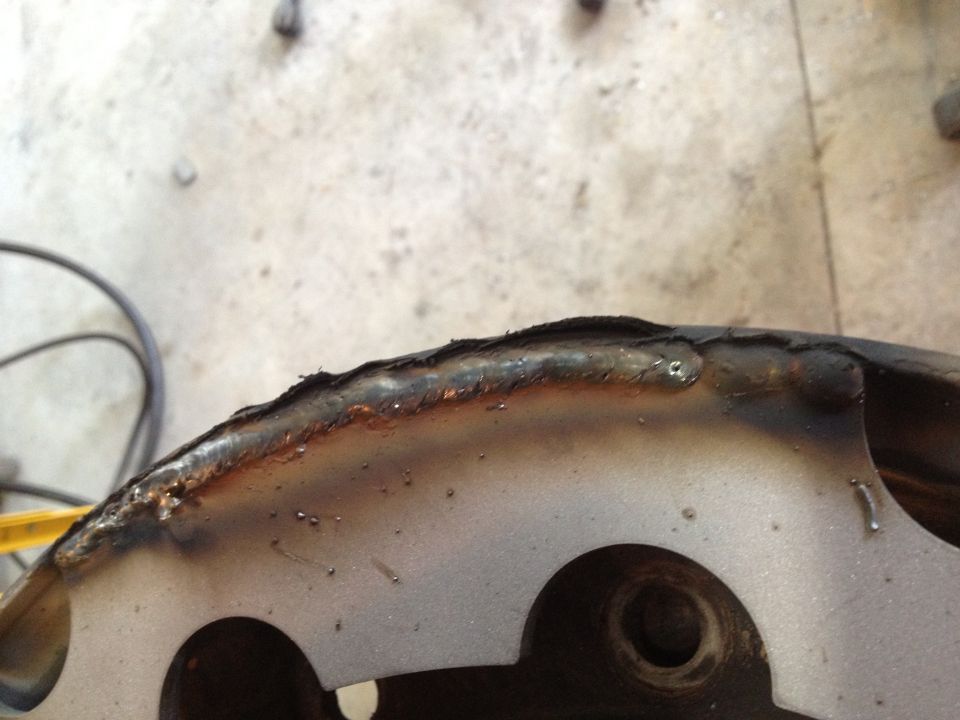 Welded metal part with circular cutouts and visible weld marks