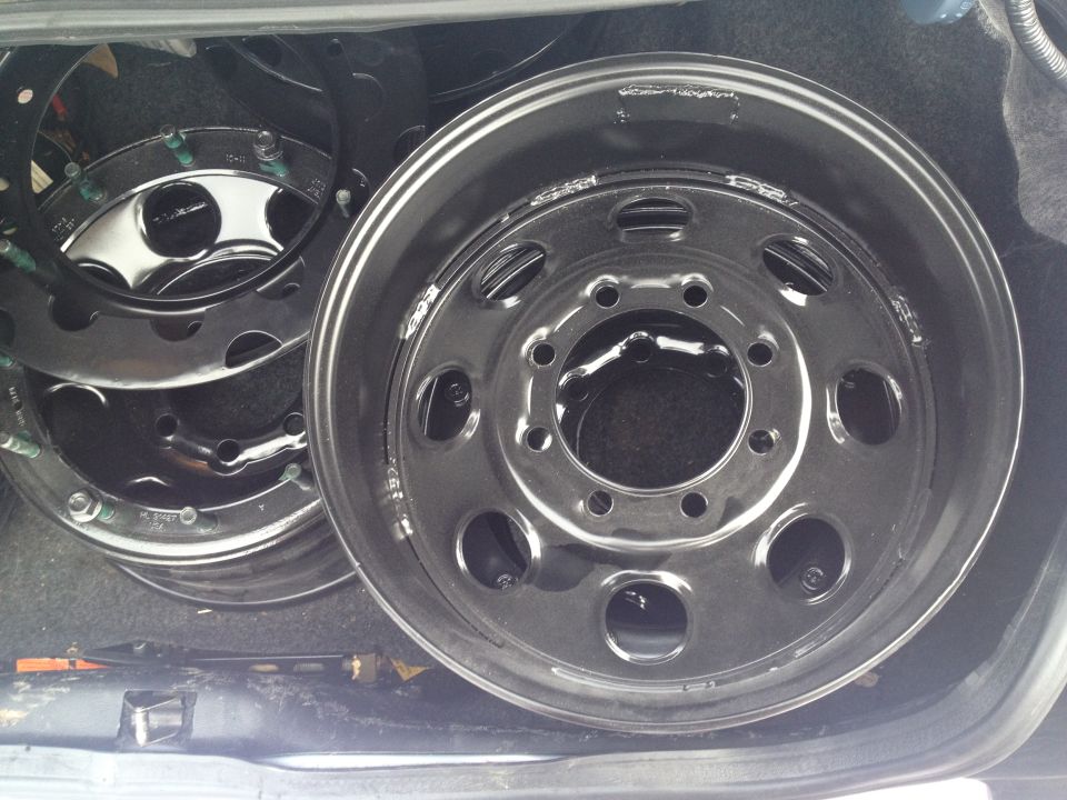 stack of shiny metal truck rims in a cargo area